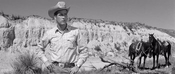 Movie still from “Hud” (1963), directed by Martin Ritt – A man wearing a cowboy hat standing on a hill; Medium shot, Low angle