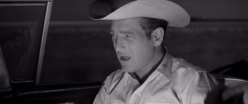 Movie still from “Hud” (1963), directed by Martin Ritt – A black and white photo of a man wearing a cowboy hat; Close Up shot, Over the shoulder angle