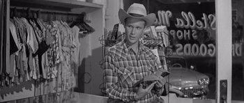 Movie still from “Hud” (1963), directed by Martin Ritt – A man in a cowboy hat is holding a cell phone; Medium shot, Over the shoulder angle