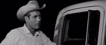 Movie still from “Hud” (1963), directed by Martin Ritt – A black and white photo of a man in a cowboy hat sitting in the driver's seat of a truck; Close Up shot, Low angle