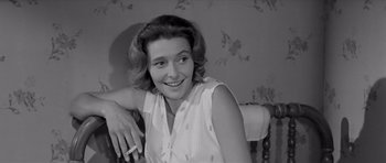 Movie still from “Hud” (1963), directed by Martin Ritt – A black - and - white photo of a woman smoking a cigarette; Close Up shot, Over the shoulder angle