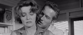 Movie still from “Hud” (1963), directed by Martin Ritt – A man and a woman standing next to each other; Close Up shot, Over the shoulder angle