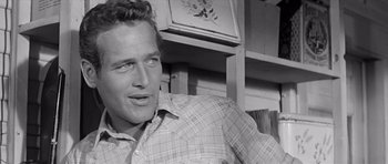 Movie still from “Hud” (1963), directed by Martin Ritt – A black - and - white photo of a man in a plaid shirt; Close Up shot, Over the shoulder angle