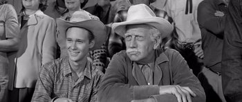 Movie still from “Hud” (1963), directed by Martin Ritt – Two men sitting next to each other wearing hats; Medium shot, Over the shoulder angle