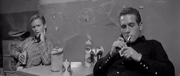 Movie still from “Hud” (1963), directed by Martin Ritt – A black and white photo of a man smoking a cigarette; Medium shot, Low angle