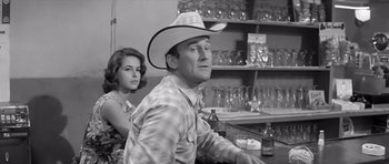 Movie still from “Hud” (1963), directed by Martin Ritt – A man and a woman sitting at a bar; Medium shot, Low angle