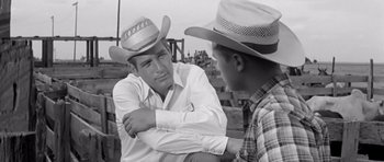 Movie still from “Hud” (1963), directed by Martin Ritt – A man in a cowboy hat talking to another man; Medium shot, Over the shoulder angle