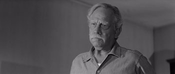 Movie still from “Hud” (1963), directed by Martin Ritt – An older man with a beard and mustache wearing a shirt; Close Up shot, Low angle