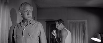 Movie still from “Hud” (1963), directed by Martin Ritt – Two men are standing in a room and one is holding a cell phone; Medium shot, Low angle
