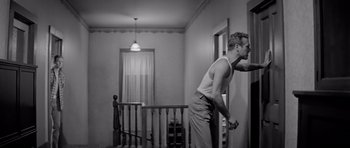 Movie still from “Hud” (1963), directed by Martin Ritt – A man standing in front of a wall in a room; Medium shot, Low angle