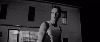 Movie still from “Hud” (1963), directed by Martin Ritt – Black and white photograph of a man in front of a building; Close Up shot, Low angle