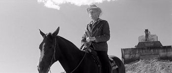 Movie still from “Hud” (1963), directed by Martin Ritt – An old man riding on a horse in a field; Medium shot, Low angle