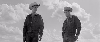 Movie still from “Hud” (1963), directed by Martin Ritt – Two men in cowboy hats standing next to each other; Medium shot, Low angle