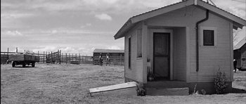 Movie still from “Hud” (1963), directed by Martin Ritt – An old photo of a farm with a horse trough in front of it; Extreme Wide shot, Low angle