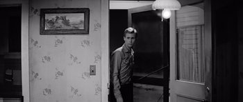 Movie still from “Hud” (1963), directed by Martin Ritt – A young man standing in a doorway of a house; Medium shot, Over the shoulder angle