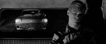 Movie still from “Hud” (1963), directed by Martin Ritt – Black and white photograph of a man in front of a car; Close Up shot, Low angle