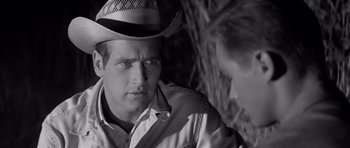 Movie still from “Hud” (1963), directed by Martin Ritt – A black and white photo of a man wearing a cowboy hat; Close Up shot, Over the shoulder angle