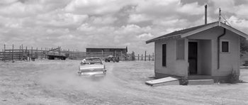 Movie still from “Hud” (1963), directed by Martin Ritt – An old photo of a car driving down a road; Extreme Wide shot, Low angle