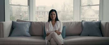 Movie still from “Hustlers” (2019), directed by Lorene Scafaria – A woman sitting on a couch in front of a window; Medium shot, Low angle