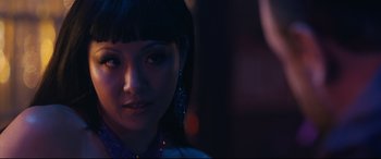 Movie still from “Hustlers” (2019), directed by Lorene Scafaria – A person wearing a dress with lights in the background; Close Up shot, Over the shoulder angle