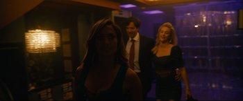 Movie still from “Hustlers” (2019), directed by Lorene Scafaria – A group of people standing in a dark room; Medium shot, Over the shoulder angle