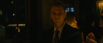 Movie still from “Hustlers” (2019), directed by Lorene Scafaria – A man wearing a suit and tie in a dark room; Close Up shot, Low angle