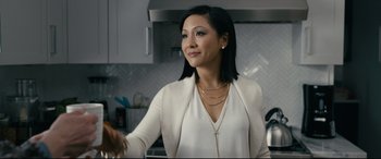 Movie still from “Hustlers” (2019), directed by Lorene Scafaria – A woman in a white shirt and a white jacket in a kitchen; Medium shot, Over the shoulder angle