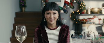 Movie still from “Hustlers” (2019), directed by Lorene Scafaria – A woman with long black hair wearing a striped shirt; Close Up shot, Over the shoulder angle