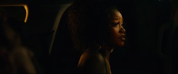 Movie still from “Hustlers” (2019), directed by Lorene Scafaria – A beautiful woman with long black curly hair looking to her left; Close Up shot, Over the shoulder angle