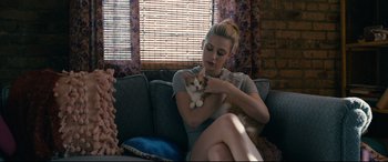 Movie still from “Hustlers” (2019), directed by Lorene Scafaria – A woman sitting on a couch holding a cat; Medium shot, High angle