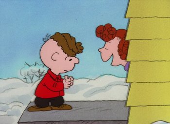 Movie still from “It's Christmastime Again, Charlie Brown” (1992), directed by Bill Melendez – A charlie brown and a shaggy haired girl are standing together; Medium shot, High angle