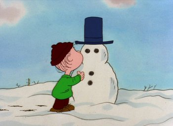 Movie still from “It's Christmastime Again, Charlie Brown” (1992), directed by Bill Melendez – A charlie brown character kissing the head of a snowman; Extreme Close Up shot, Low angle