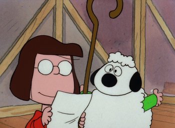 Movie still from “It's Christmastime Again, Charlie Brown” (1992), directed by Bill Melendez – A woman is reading a paper next to a sheep; Close Up shot, Over the shoulder angle