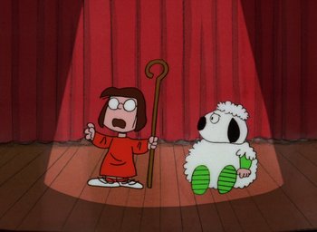 Movie still from “It's Christmastime Again, Charlie Brown” (1992), directed by Bill Melendez – A cartoon of jesus and a sheep on a stage; Wide shot, Low angle