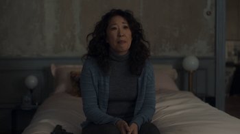 Movie still from “Killing Eve” (2018), created by Phoebe Waller-Bridge – A woman sitting on a bed in the dark; Medium shot, Over the shoulder angle