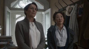Movie still from “Killing Eve” (2018), created by Phoebe Waller-Bridge – Two women standing next to each other in front of a window; Medium shot, Over the shoulder angle