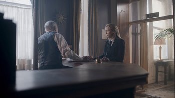 Movie still from “Killing Eve” (2018), created by Phoebe Waller-Bridge – A man and a woman sitting in front of a window; Medium shot, Over the shoulder angle