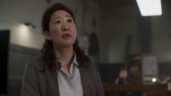 Movie still from “Killing Eve” (2018), created by Phoebe Waller-Bridge – A woman in a suit looking up at the ceiling; Close Up shot, Over the shoulder angle
