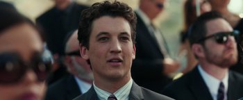 Movie still from “War Dogs” (2016), directed by Todd Phillips – A man in a suit and tie looking at the camera; Close Up shot, Over the shoulder angle