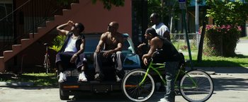 Movie still from “War Dogs” (2016), directed by Todd Phillips – A group of men sitting on the back of a truck; Wide shot, Over the shoulder angle