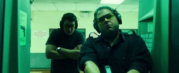 Movie still from “War Dogs” (2016), directed by Todd Phillips – Two men wearing headphones and glasses in a room; Medium shot, Low angle