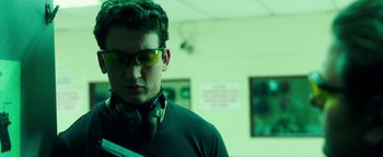 Movie still from “War Dogs” (2016), directed by Todd Phillips – A man with glasses and headphones looking down; Close Up shot, Low angle