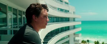 Movie still from “War Dogs” (2016), directed by Todd Phillips – A man standing in front of a tall building; Close Up shot, Low angle