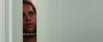 Movie still from “War Dogs” (2016), directed by Todd Phillips – A person with a chain around their neck; Close Up shot, Over the shoulder angle
