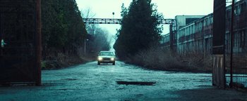 Movie still from “War Dogs” (2016), directed by Todd Phillips – A car driving down a road near trees and bushes; Extreme Wide shot, Low angle