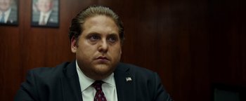 Movie still from “War Dogs” (2016), directed by Todd Phillips – A person wearing a suit and tie; Close Up shot, Over the shoulder angle