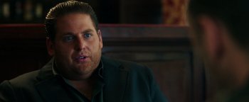 Movie still from “War Dogs” (2016), directed by Todd Phillips – A person wearing a suit and tie; Close Up shot, Over the shoulder angle