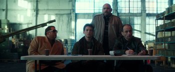 Movie still from “War Dogs” (2016), directed by Todd Phillips – A group of people sitting at a table; Medium shot, Low angle