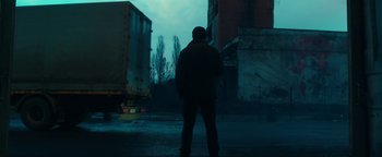 Movie still from “War Dogs” (2016), directed by Todd Phillips – A man standing on the side of the road in the dark; Wide shot, Low angle