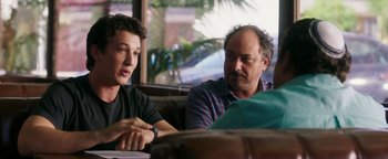 Movie still from “War Dogs” (2016), directed by Todd Phillips – A man and a woman sitting at a table talking to each other; Close Up shot, Over the shoulder angle